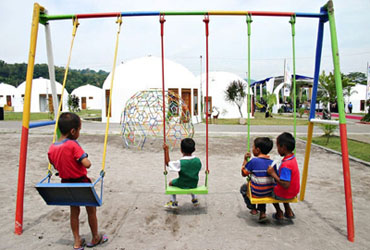 Image of children in a playground of a dome village.